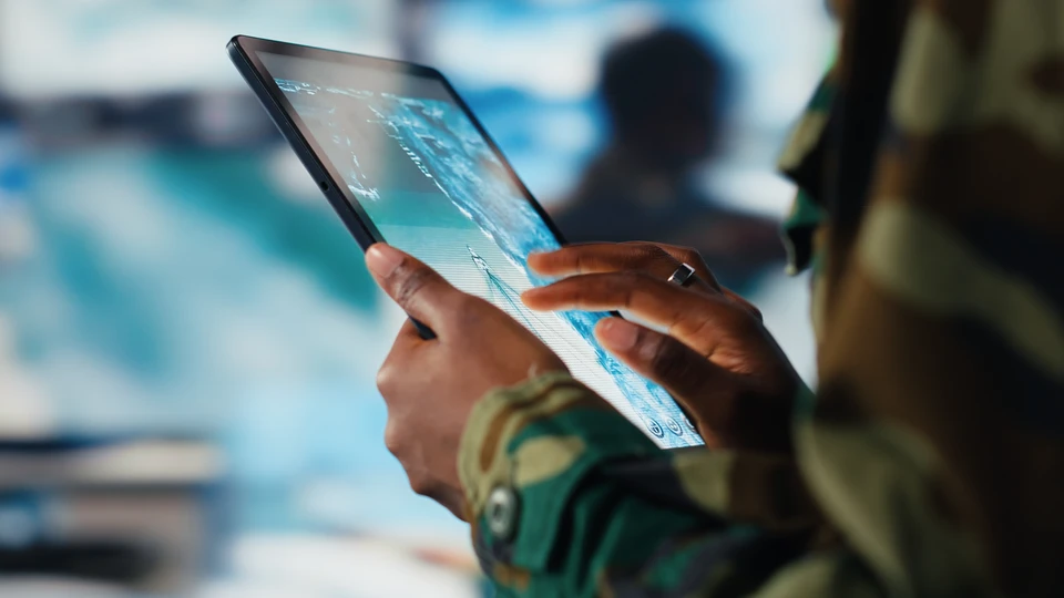 Espace de travail moderne avec homme d'affaires analysant des données sur tablette tactile et ordinateur portable